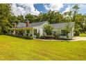 White one-story house with a large front porch and a nicely landscaped yard at 1404 Plateau Dr, Brooksville, FL 34602