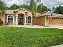 House exterior featuring double doors and welcoming sign at 10539 Audie Brook Dr, Spring Hill, FL 34608