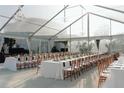 Elegant banquet hall features rectangular tables with white linens and wooden chairs under bright chandeliers at 10603 Low Oak Ter, Thonotosassa, FL 33592