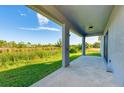 Covered patio with outdoor shower offering stunning views of the lush greenery and tranquil canal at 15154 Appleton Blvd, Port Charlotte, FL 33981