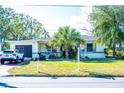 House exterior featuring a light-colored facade, lush landscaping, and a driveway at 2109 58Th S St, Gulfport, FL 33707