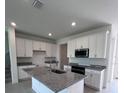 Contemporary kitchen with white cabinets, granite counters, and stainless appliances at 31907 Anchor Point Dr, Wesley Chapel, FL 33545