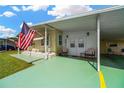Inviting covered entrance, adorned with seating and patriotic decor at 7048 El Meyers St, Zephyrhills, FL 33541