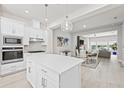 Bright kitchen boasts an island, white cabinets, stainless appliances, herringbone backsplash, and open floor plan at 2510 W Cleveland St # 2, Tampa, FL 33609