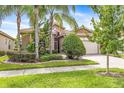 Beautifully landscaped single-story home featuring a well-manicured lawn and a side-entry garage at 4949 Sandy Brook Cir, Wimauma, FL 33598