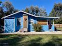 Blue house with a pink door and unique sun art at 1478 Alternate Keene Rd, Largo, FL 33771