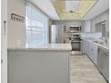 Bright kitchen featuring stainless steel appliances, granite countertops, and grey cabinets at 1370 Heather Ridge Blvd # 107, Dunedin, FL 34698
