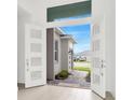 Open double front doors reveal a view of a landscaped walkway and a garage at 32252 Wetland Bird Vw, San Antonio, FL 33576