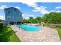 Outdoor pool and patio area with landscaped yard, hot tub, and play structure at 6419 Marbella Blvd, Apollo Beach, FL 33572