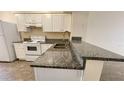 Kitchen features granite countertops and white cabinets at 11335 Grandville Dr, Temple Terrace, FL 33617