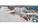 Aerial view of condo building, pool, beach, and surrounding area at 4950 Gulf Blvd # 104, St Pete Beach, FL 33706