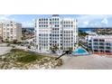 Aerial view showcasing condo building, pool, and beach proximity at 4950 Gulf Blvd # 104, St Pete Beach, FL 33706
