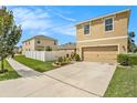 Two-story house with driveway, landscaping and a white fence at 3508 Diamond Leaf Ct, Valrico, FL 33594