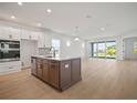 Open-concept kitchen with an island, stainless steel appliances, and seamless flow into the spacious living area at 11963 Richmond Trl, Parrish, FL 34219