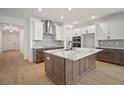Well-lit kitchen featuring a large island, stainless steel appliances, and views of the hallway and front door at 11963 Richmond Trl, Parrish, FL 34219