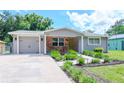 Cute house with a brick facade, attached garage, and nicely landscaped yard at 9717 N Rome Ave, Tampa, FL 33612