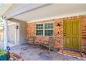 Inviting front porch with brick columns, seating area, and a welcoming mat at 9717 N Rome Ave, Tampa, FL 33612