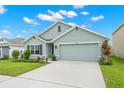 Single-story house with a two-car garage and landscaped lawn at 16758 Sunburst Lake St, Wimauma, FL 33598