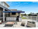 Outdoor kitchen with built-in grill, bar seating, and patio furniture at 528 Islebay Dr, Apollo Beach, FL 33572