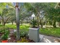 Landscaped patio area with seating, overlooking a serene backyard view at 251 Hidden Brook Dr # 102C, Palm Harbor, FL 34683