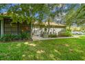 Backyard view showing a screened porch and lush green lawn at 251 Hidden Brook Dr # 102C, Palm Harbor, FL 34683