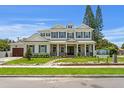 Beautiful two-story home featuring white brick, a covered porch with columns, and lush landscaping at 4536 W Swann Ave, Tampa, FL 33629