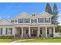 Elegant home showcasing white columns, a covered porch, and manicured landscaping under a blue sky at 4536 W Swann Ave, Tampa, FL 33629
