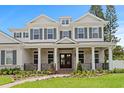 Elegant home showcasing white columns, a covered porch, and manicured landscaping under a blue sky at 4536 W Swann Ave, Tampa, FL 33629