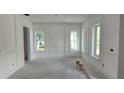 Bright, unfinished living room featuring new wall trim and large windows providing ample natural light at 610 Ontario Ave, Tampa, FL 33606