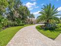 Luxury home with circular driveway and lush landscaping at 1299 Coverstone Ct, Oldsmar, FL 34677