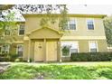 Tan two-story townhome with two light beige doors at 36121 Lake Chase Blvd # 204, Zephyrhills, FL 33541