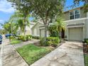 Townhome with a driveway and lush landscaping at 2748 Birchcreek Dr, Wesley Chapel, FL 33544