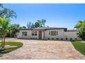 Charming single story home with brick driveway, manicured lawn and beautiful landscaping at 6750 W Flamingo S Way, St Petersburg, FL 33707