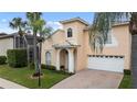 Two-story house with a peach-colored exterior, white garage door, and lush landscaping at 10713 Cape Hatteras Dr, Tampa, FL 33615