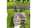 Two-story house with a brown roof, situated on a grassy lot near a wetland at 35716 Hillbrook Ave, Zephyrhills, FL 33541