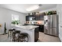 Modern kitchen with dark cabinets, stainless steel appliances, and an island at 35716 Hillbrook Ave, Zephyrhills, FL 33541