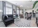 Open-concept living room with sectional sofa and large windows at 5014 Ruby Flats Dr, Wimauma, FL 33598