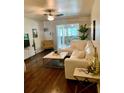 Spacious living room with L-shaped sectional sofa and hardwood floors at 500 Glennes Ln # 206, Dunedin, FL 34698