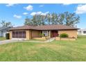Single story home with brown roof and red door at 8227 Rhanbuoy Rd, Spring Hill, FL 34606