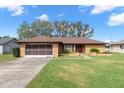 Single story home with brown roof and red door at 8227 Rhanbuoy Rd, Spring Hill, FL 34606