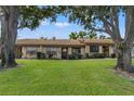 Exterior view of a charming condo unit nestled in a lush green lawn at 11241 Dollar Lake Dr # 4, Port Richey, FL 34668