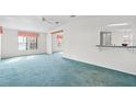 Spacious living room with an open layout, neutral walls and blue carpet, and large windows at 12501 Ulmerton Rd # 131, Largo, FL 33774