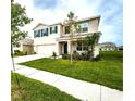 Beautiful home featuring a two-car garage, manicured lawn, and inviting front porch, all viewed from the street at 8367 Ender Hills Dr, Wesley Chapel, FL 33545