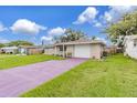 Ranch-style home with a purple driveway and well-maintained lawn at 7506 Cumber Dr, New Port Richey, FL 34653