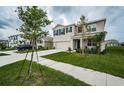 Two story house with tan exterior, landscaping and driveway at 8367 Ender Hills Dr, Wesley Chapel, FL 33545