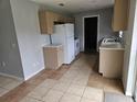 Galley kitchen with beige cabinets and tiled floors at 36131 Pine Bluff Loop, Dade City, FL 33525