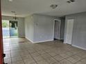 Open living room with tiled floors and access to other rooms at 36131 Pine Bluff Loop, Dade City, FL 33525