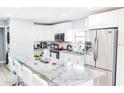 Modern kitchen with stainless steel appliances, white cabinets, and granite countertops at 8114 N Edison Ave, Tampa, FL 33604