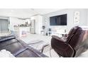Open concept living room with a large TV, leather furniture, and kitchen views at 8114 N Edison Ave, Tampa, FL 33604