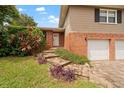 Brick home with two-car garage and walkway leading to the front door at 8212 Forest Cir, Seminole, FL 33776